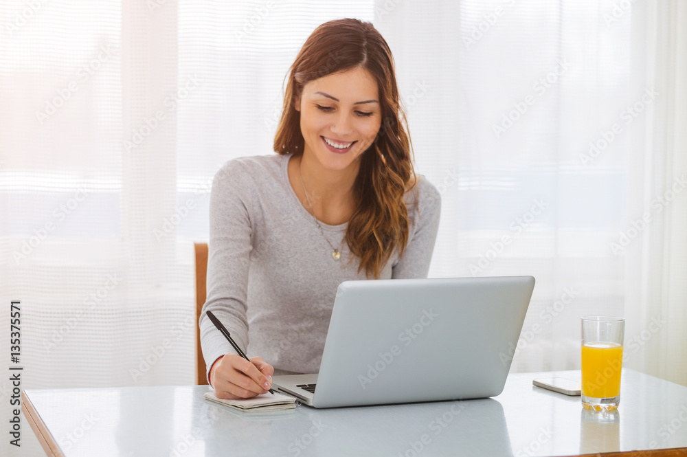 Woman freelancer female hands with pen writing on notebook at ho