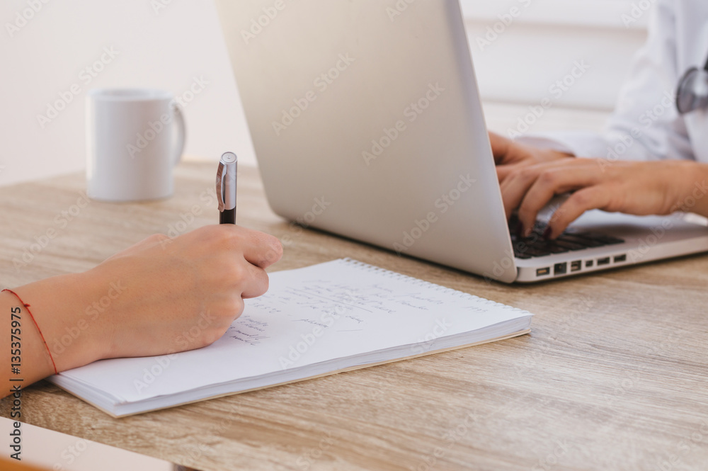 Close up of patient and doctor taking notes