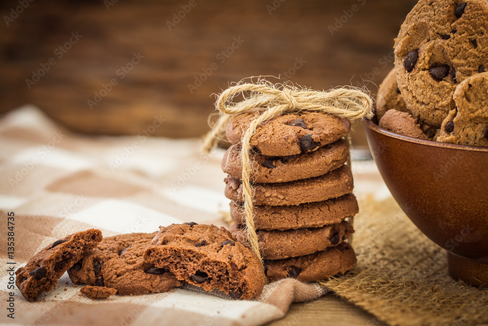 Close up stacked chocolate chip cookies on  napkin 