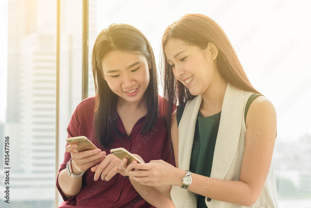 Two teenagers using smartphone share data together