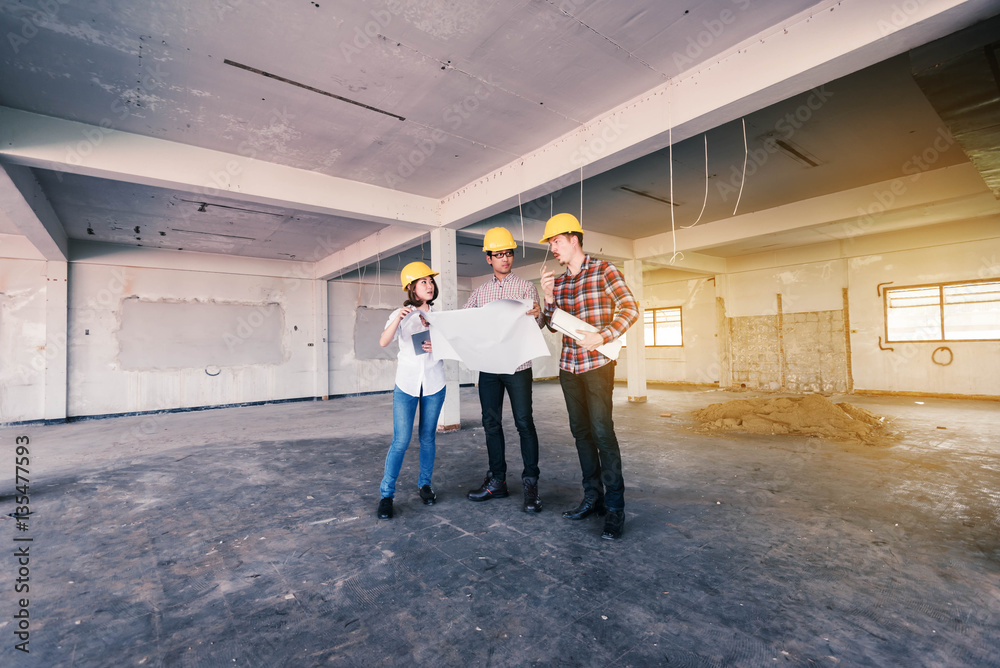 three construction engineers working together in side buiding pl