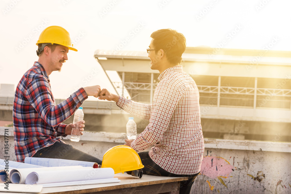 three construction engineers finished working make fist bump at