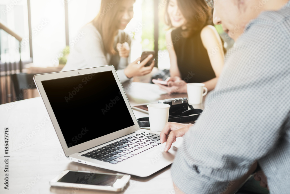 Close up scene of laptop  and group of people working in coffee