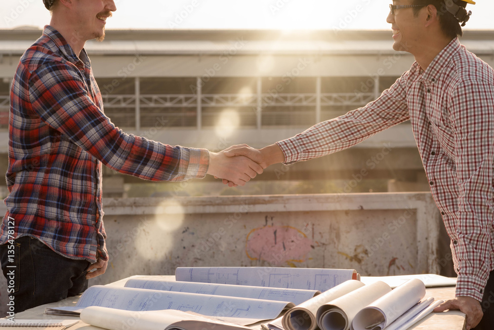 three construction engineers finished working shaking hands outd