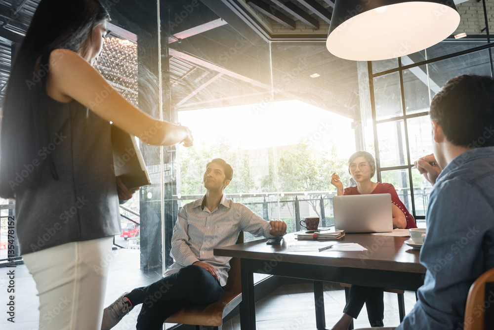 Four people discuss in meeting room