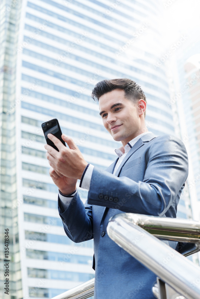 Westerner Business man talking via smart phone with skyscraper i