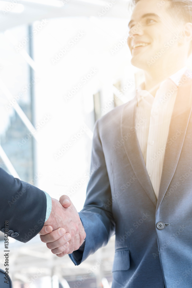 Hand shake of two businessman with sun flare, business conceptua