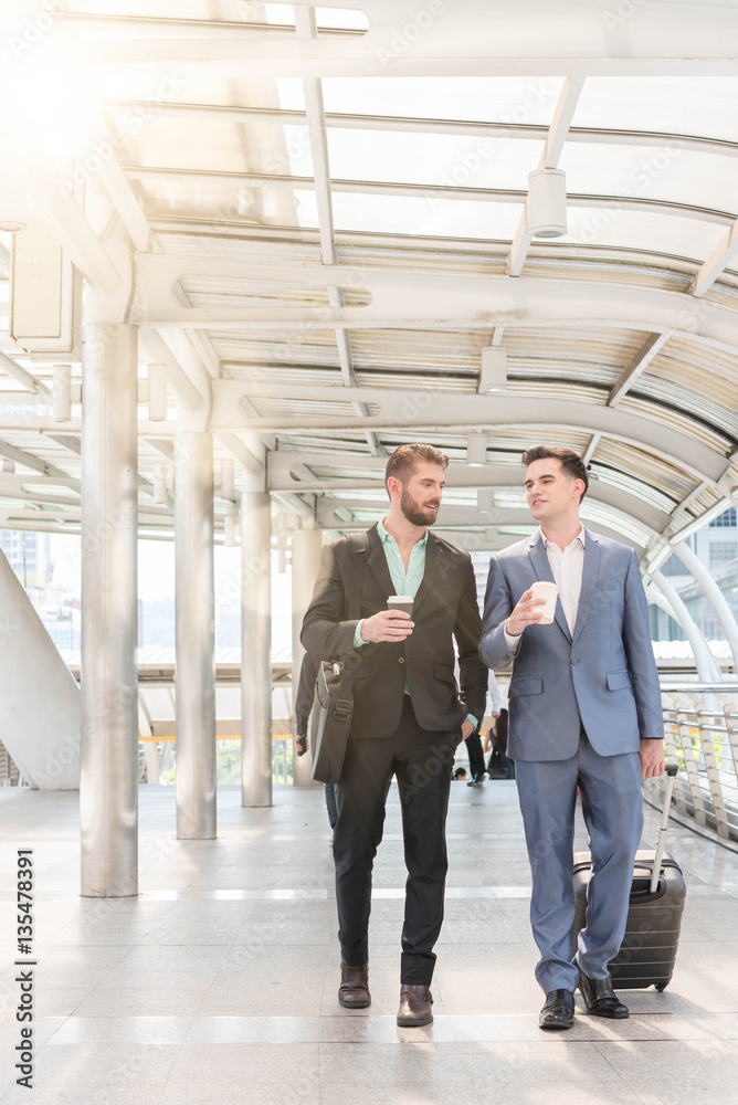 Two Westerner Business men talk with paper cup of hot coffee in