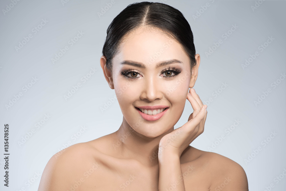 Beauty shot of young pretty asian woman with clear skin ongrey b