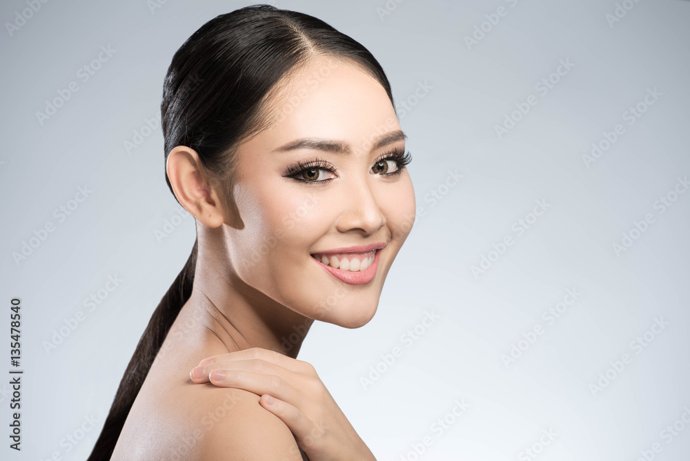 Beauty shot of young pretty asian woman with clear skin ongrey b