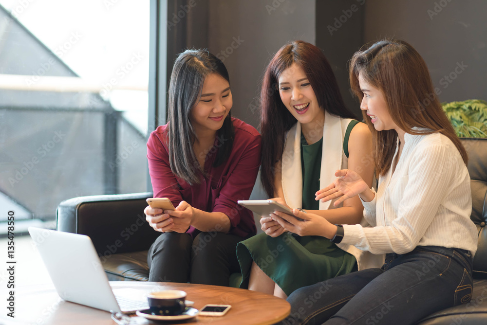 Group of friends happily hang out in a coffee shop chatting to e