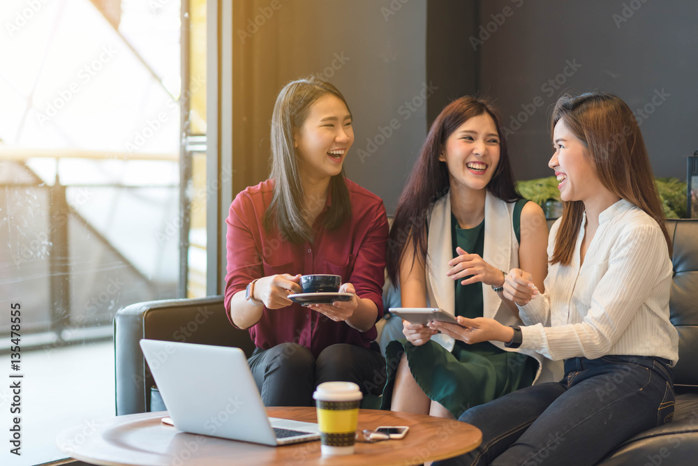 Group of friends happily hang out in a coffee shop chatting to e