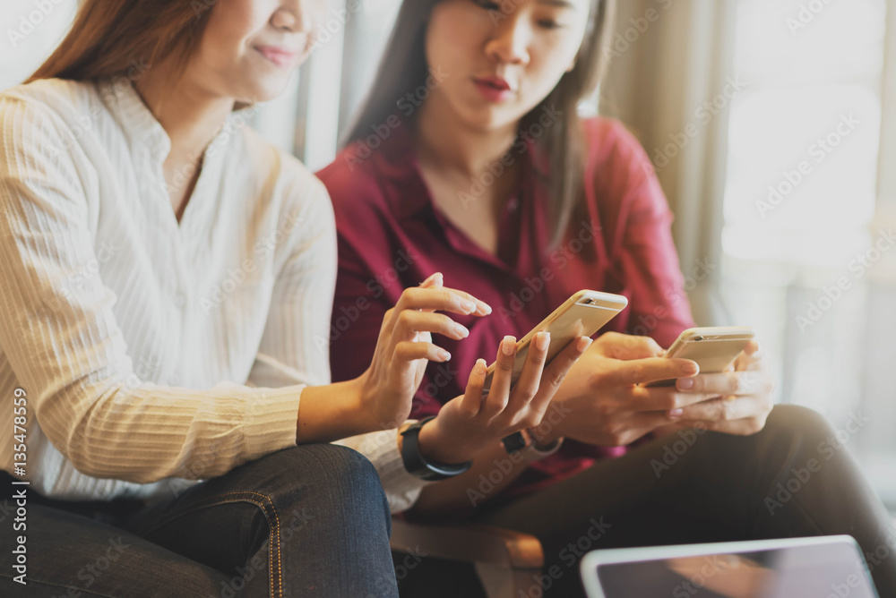 Two woman using smartphone sharing data, iot, internet of things