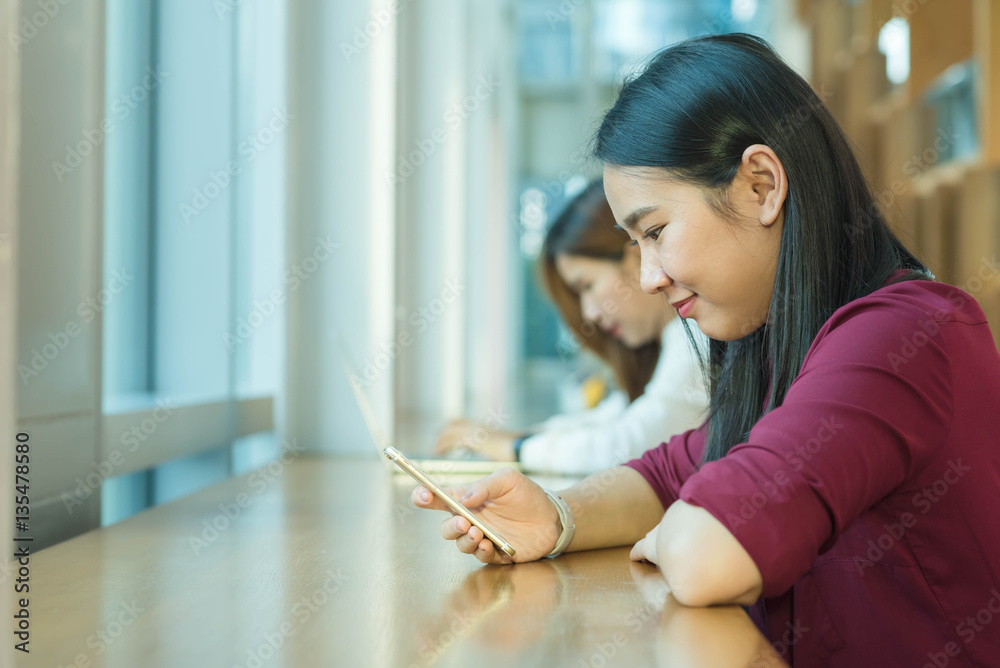 Girl use smartphone sit by the window