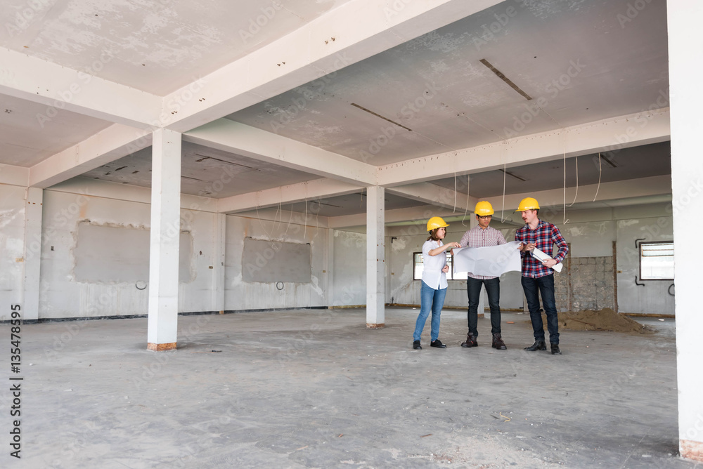 three construction engineers working together in side buiding pl