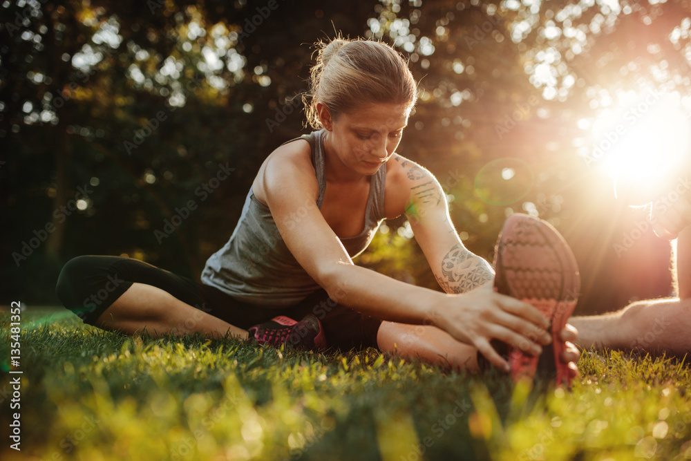 Healthy young woman exercising at park