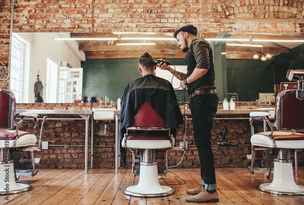 Hairstylist serving client at barber shop