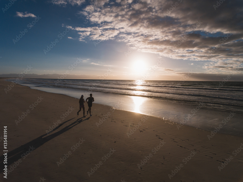 People running on the beach in morning