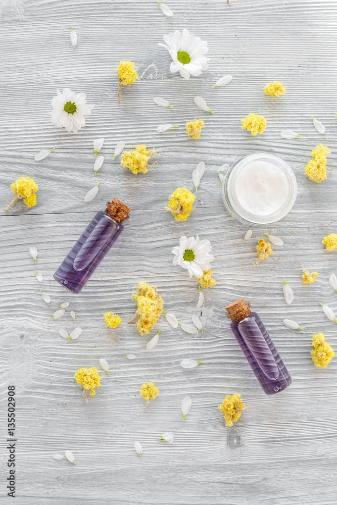 organic cosmetics with camomile on wooden background top view