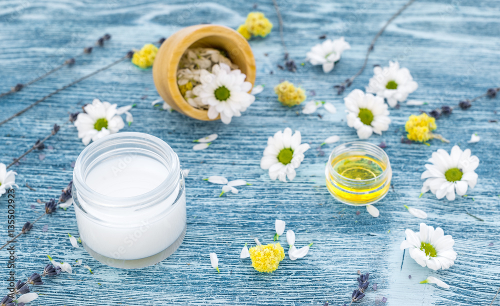 organic cosmetics with camomile on blue background