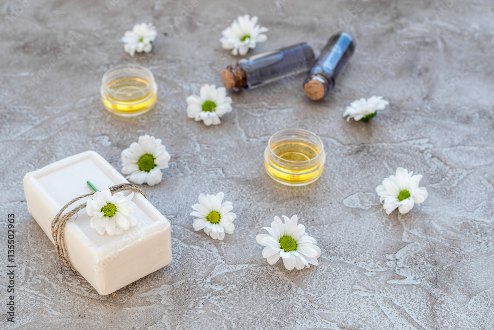 organic cosmetics with camomile on stone background