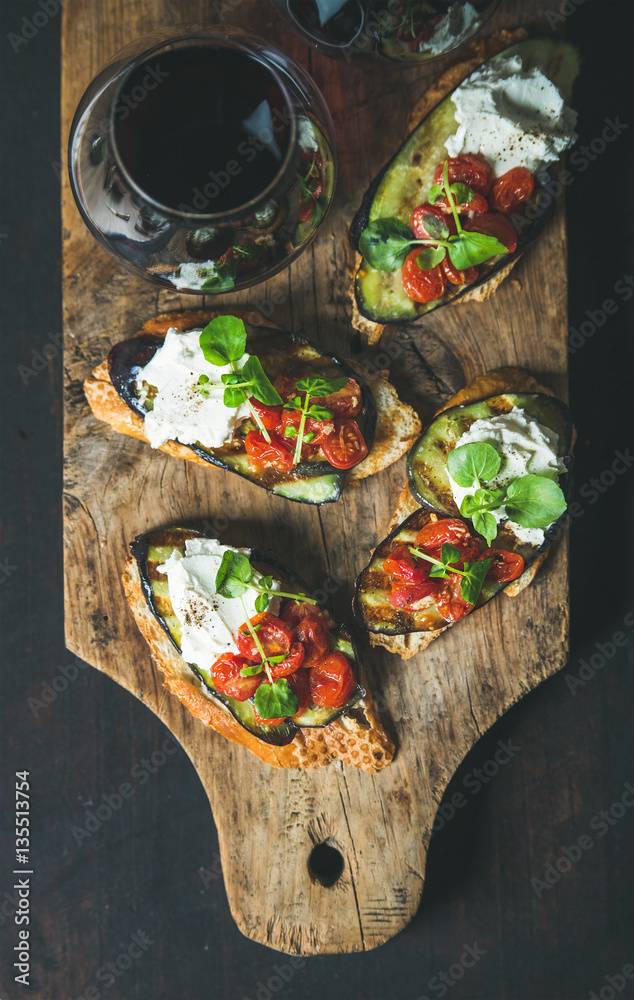 Wine and snack set. Brushetta with grilled eggplant, cherry tomatoes, garlic, cream cheese, arugula 