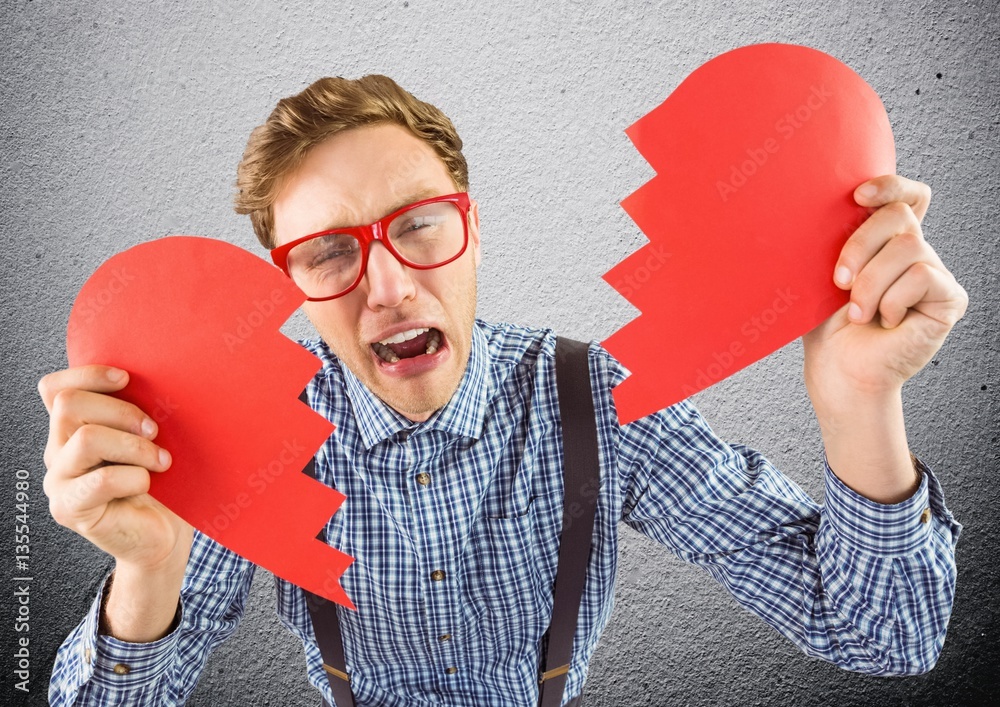 Crying man holding broken heart