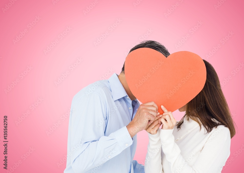 Romantic couple holding heart shape and kissing each other