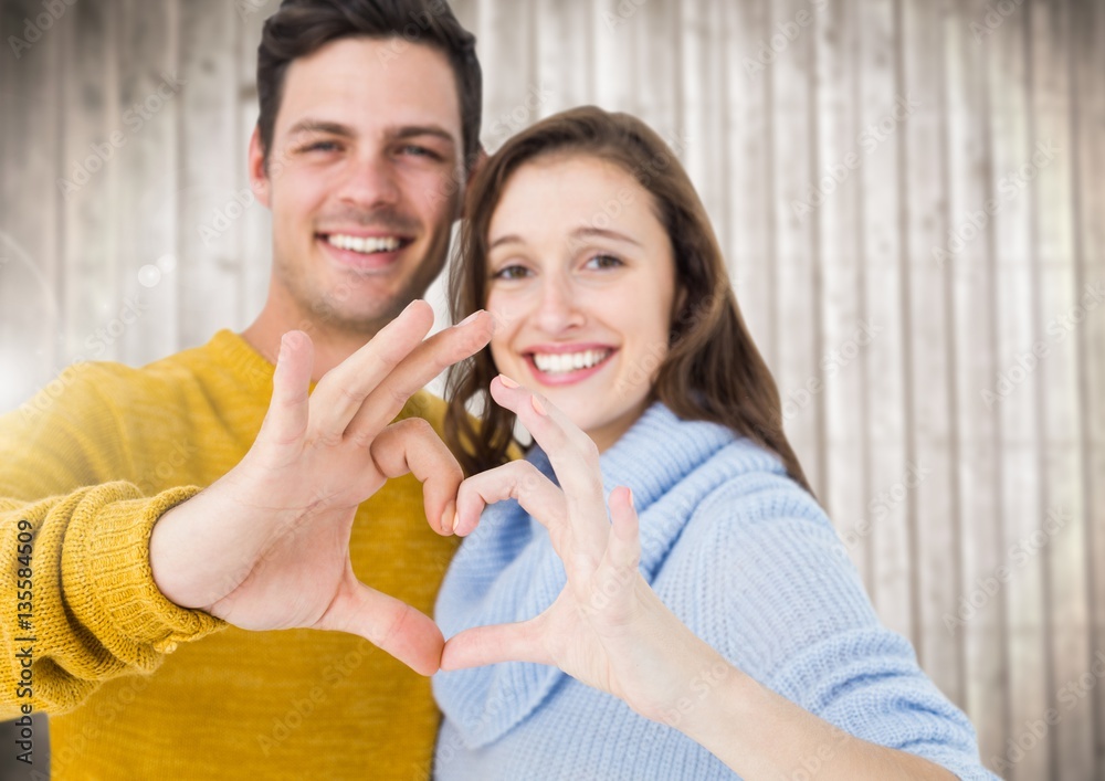 Young couple making a heart symbol with hands