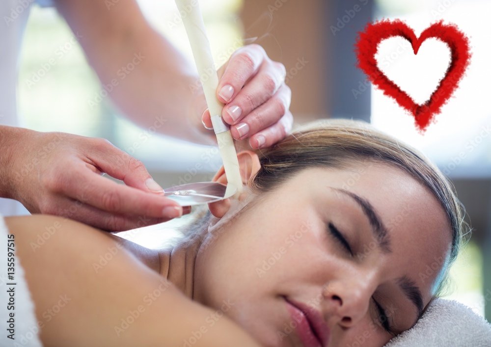 Woman receiving ear candle treatment at spa