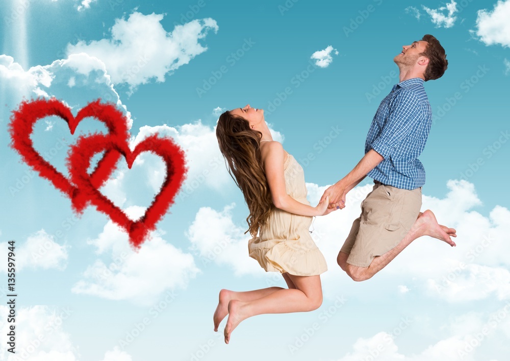 Happy couple jumping against sky background