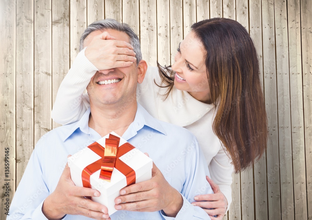 Woman covering mans eyes while gifting