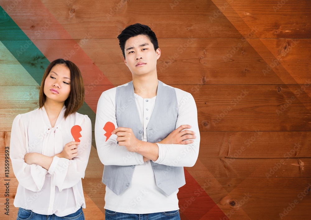 Couple holding broken heart against wooden background