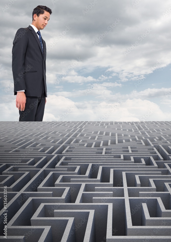 Composite image of businessman standing over maze