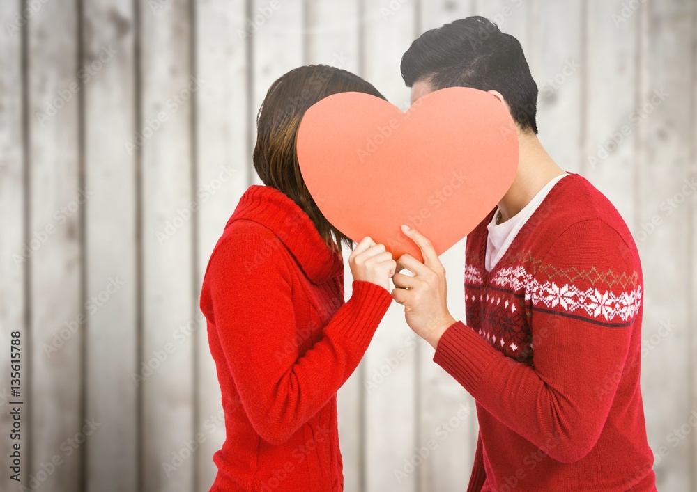 Couple kissing behind heart