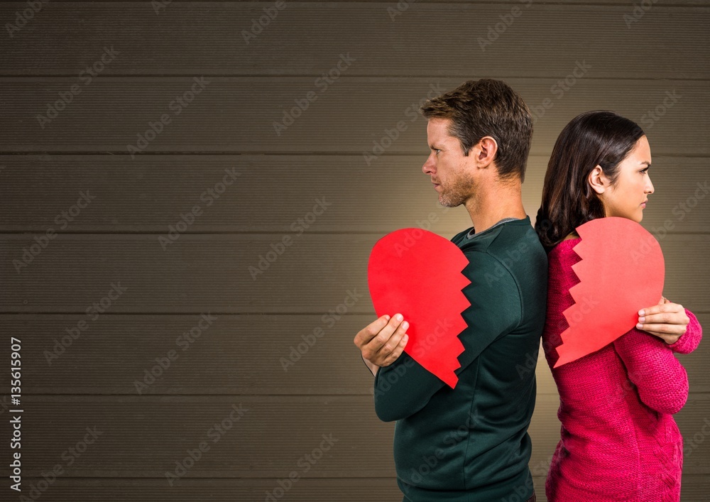 Angry couple holding broken heart