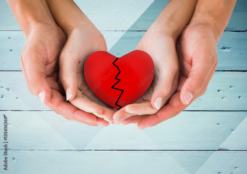 Hands of couple holding broken heart