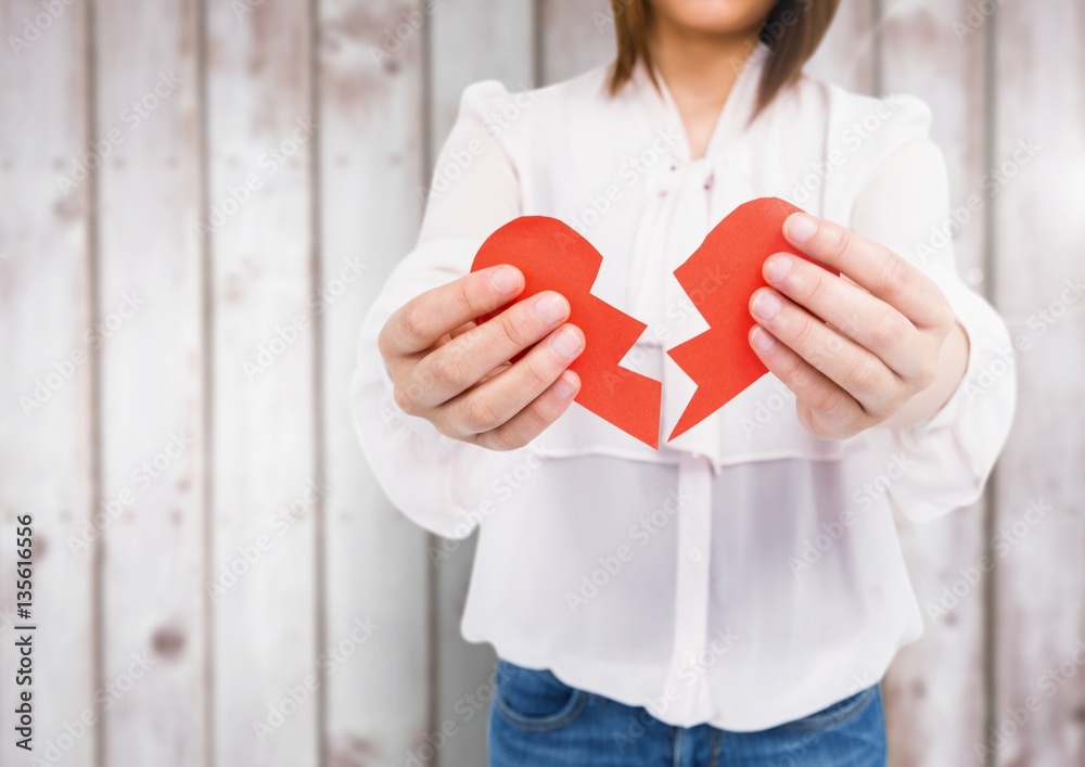 Mid-section of woman holding a broken heart