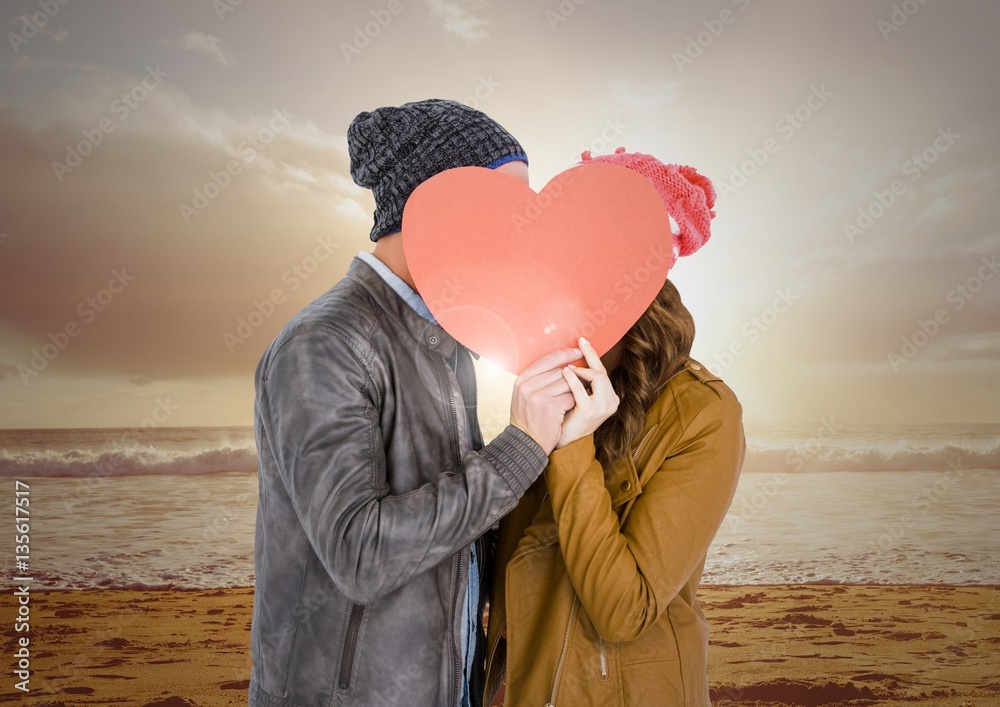 Couple kissing behind heart