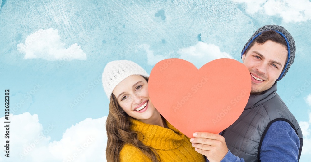 Romantic couple holding heart against sky background