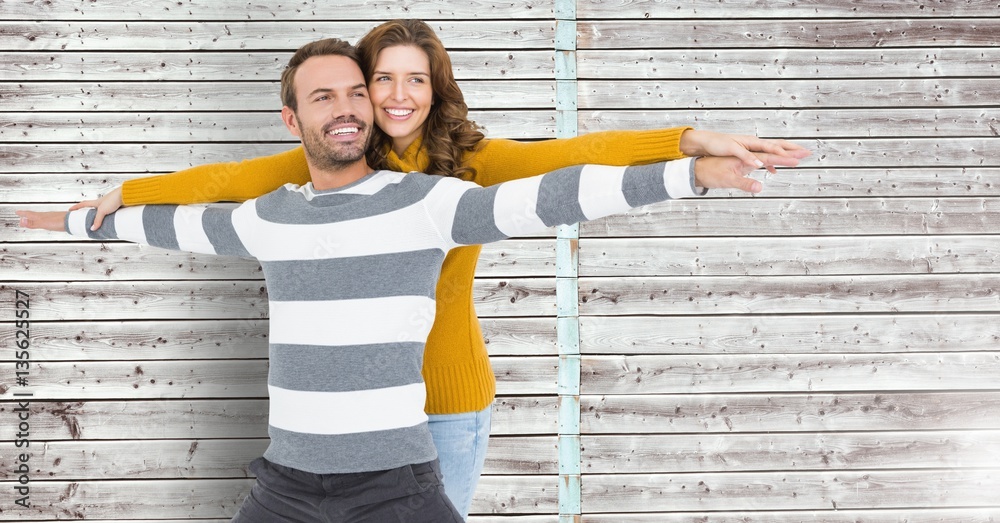 Happy couple standing with arms outstretched