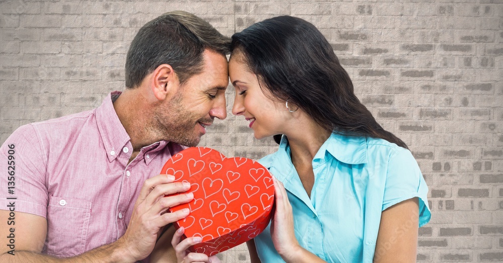 Romantic couple holding heart shape gift box