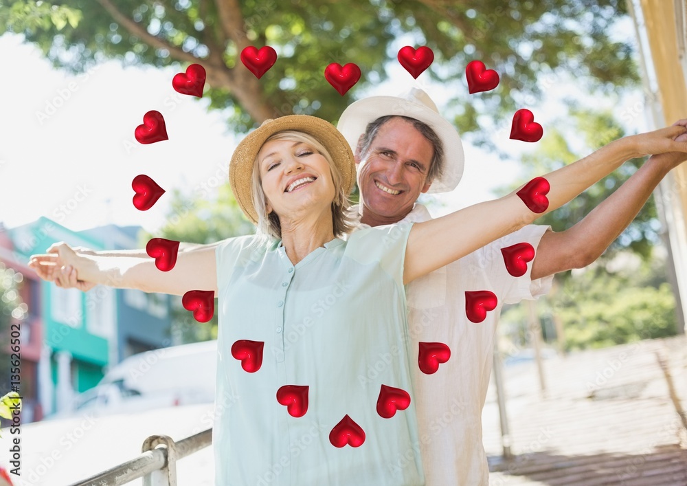 Portrait of romantic couple standing with arms outstretched