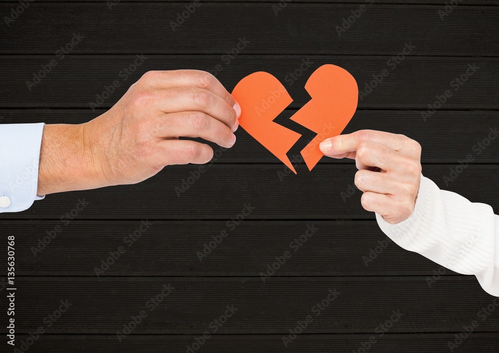 Hand of couple holding broken hearts