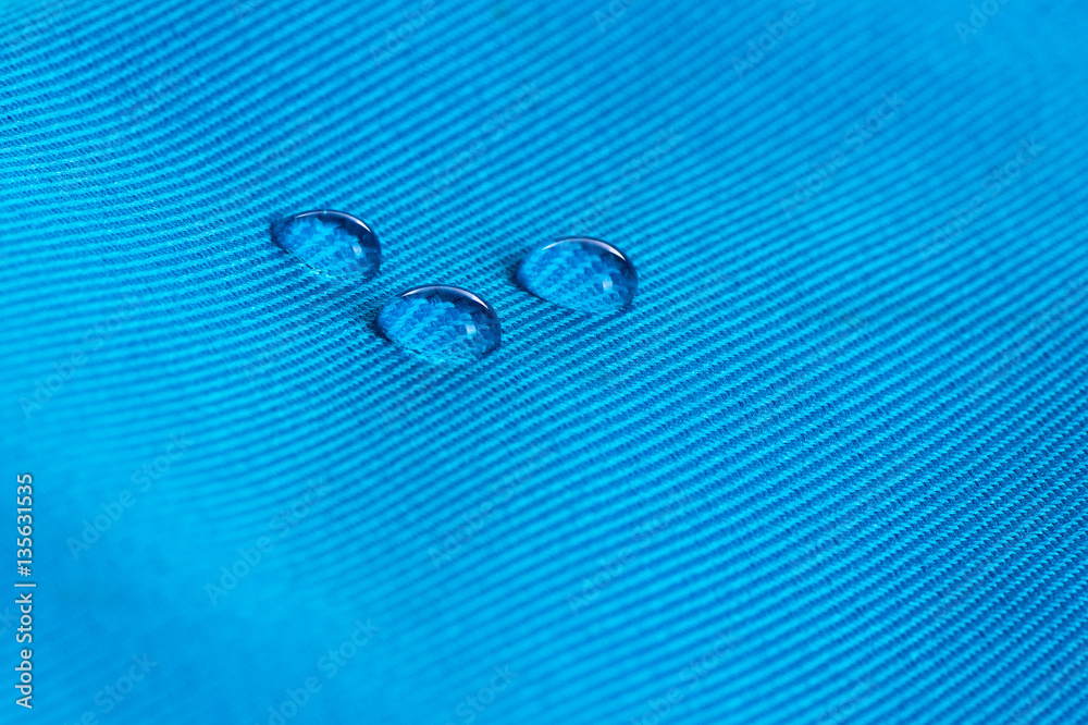 Blue waterproof fabric with waterdrops close up