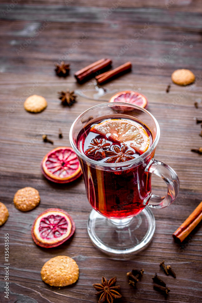 mulled wine with spices in cup on wooden background