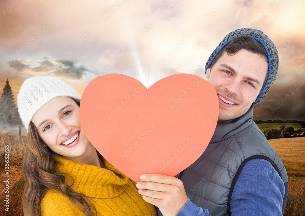 Romantic couple holding heart against sky background