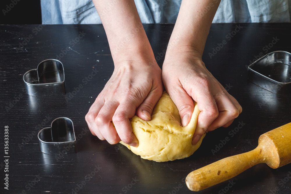 cooking homemade cookies with hands on dark background