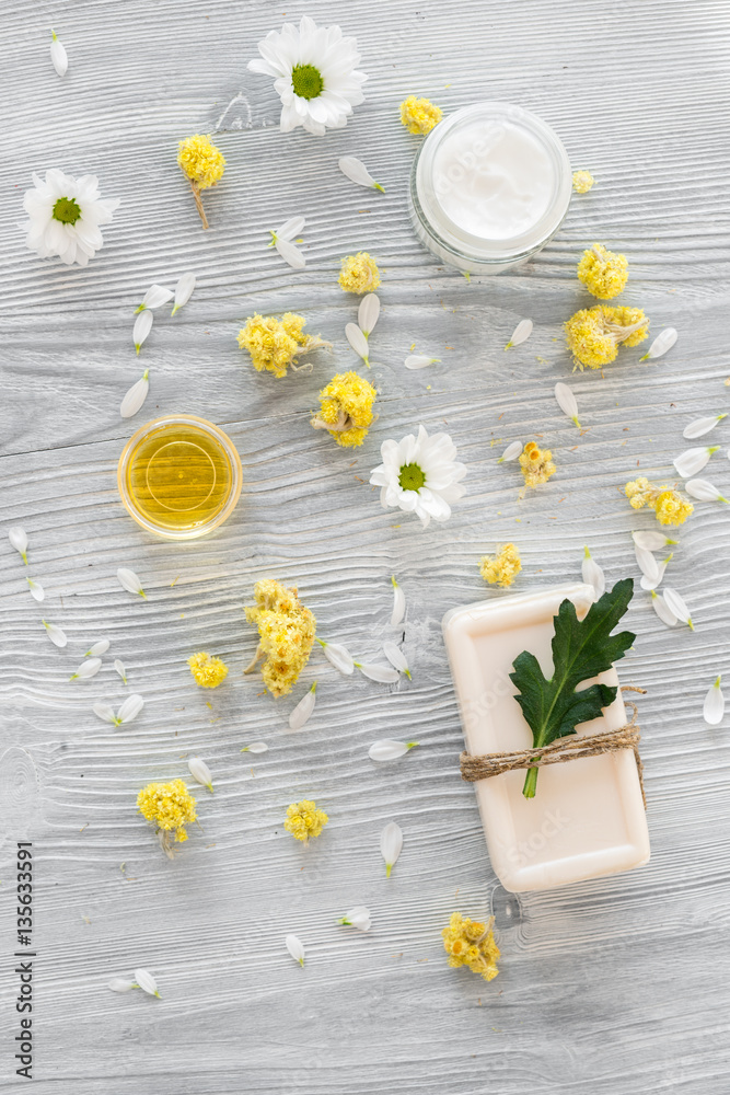 organic cosmetics with camomile on wooden background top view