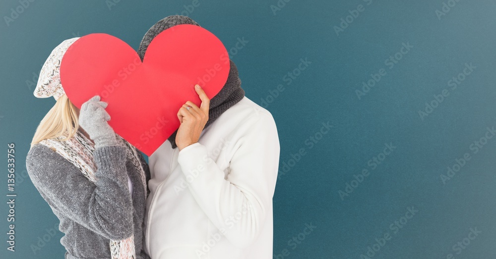 Couple hiding their face with red heart